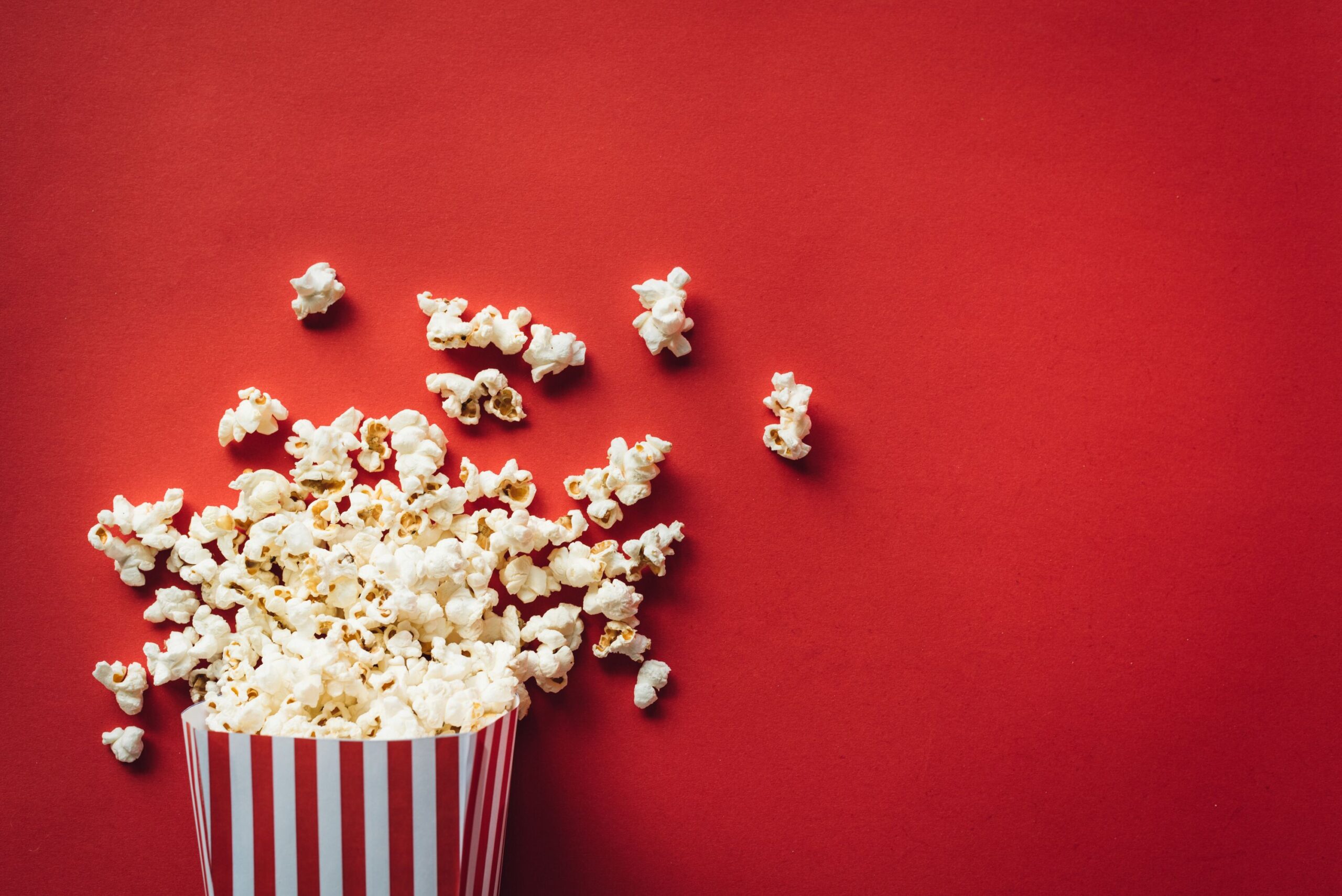 Tüte Popcorn vor rotem Hintergrund